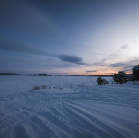 Snow covered land at sunset
