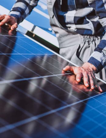 close up of solar panels with an engineer installing it